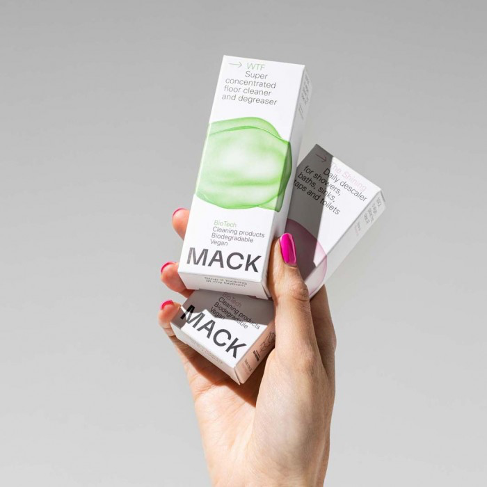hand holding up two boxes Mack concentrate floor cleaner
