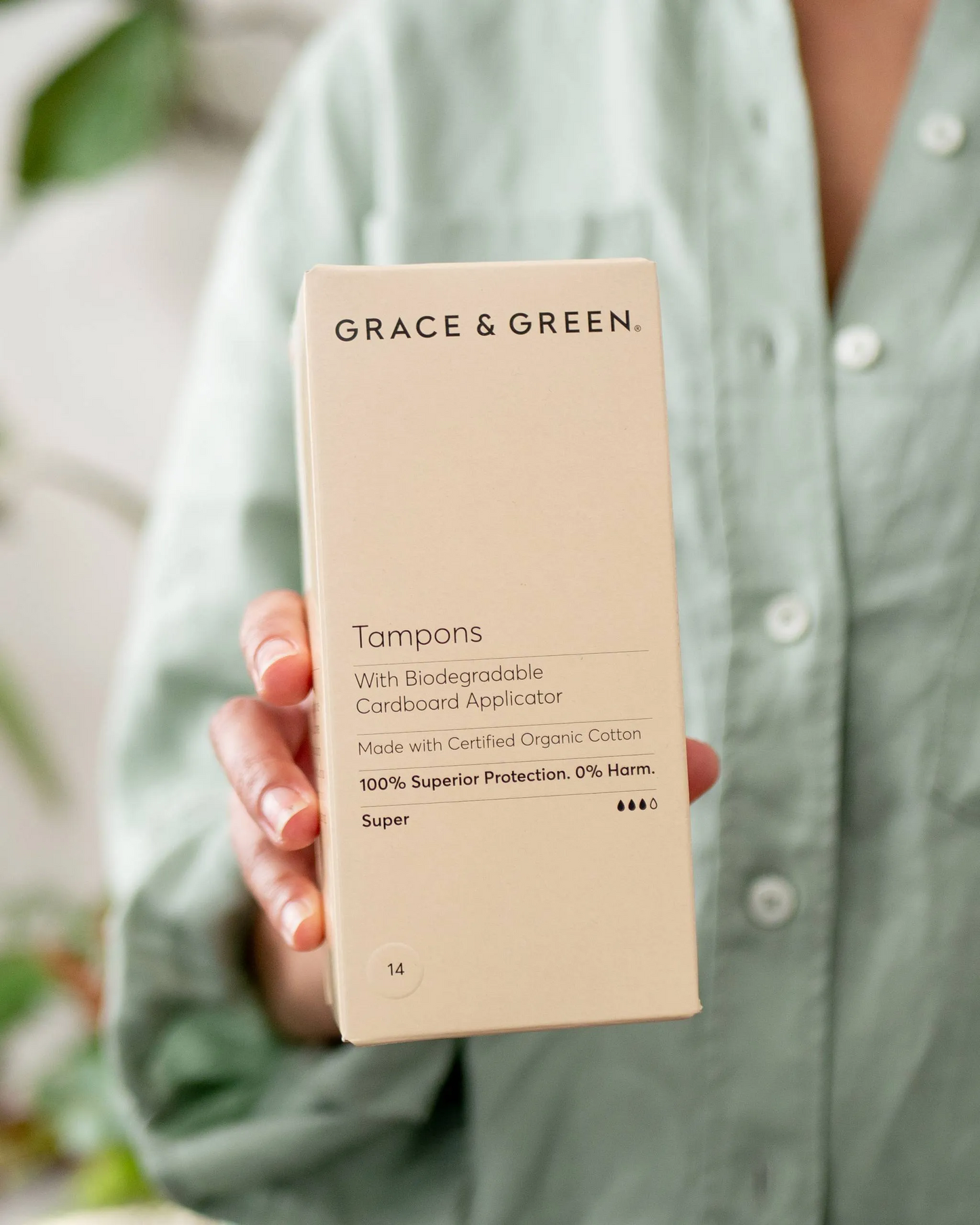 Person holding a beige box of Super organic cotton applicator tampons