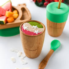 Bamboo cup filled with smoothie with bamboo spoon
