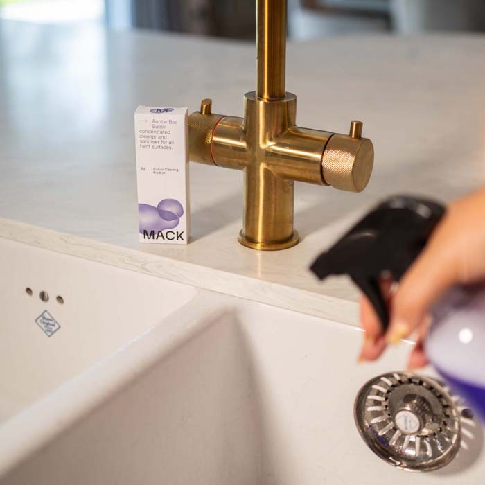 Box of Mack bio-pod concentrate sanitiser on sink with spray bottle