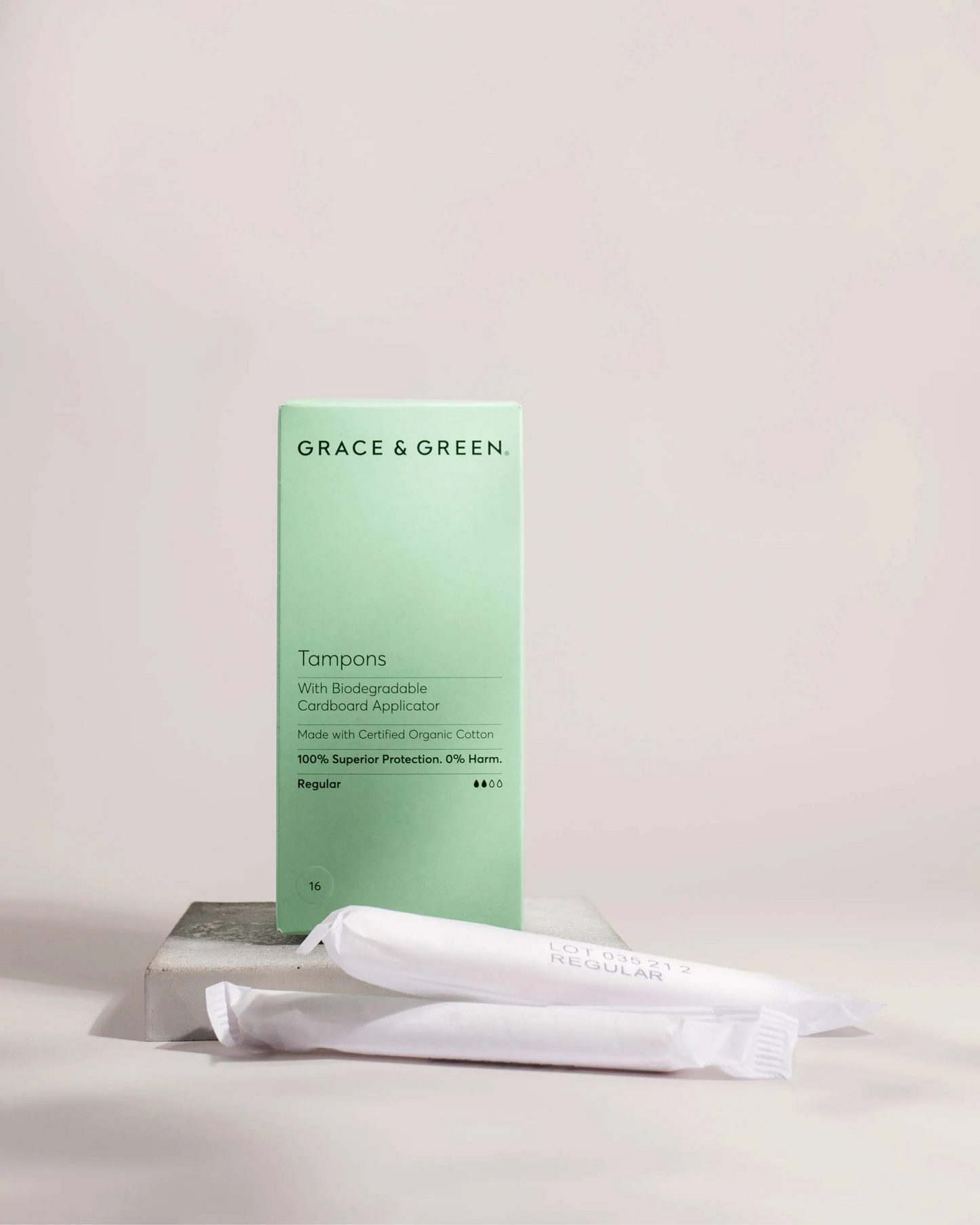 Image of green box of regular size organic applicator tampons with two individual tampons sitting next to the box