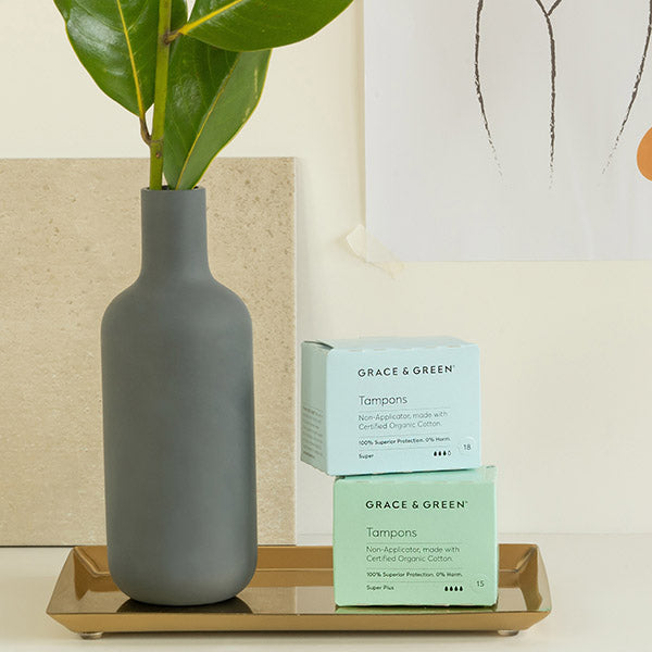Image of two boxes of organic non-applicator tampons next to a vase with a flower stem